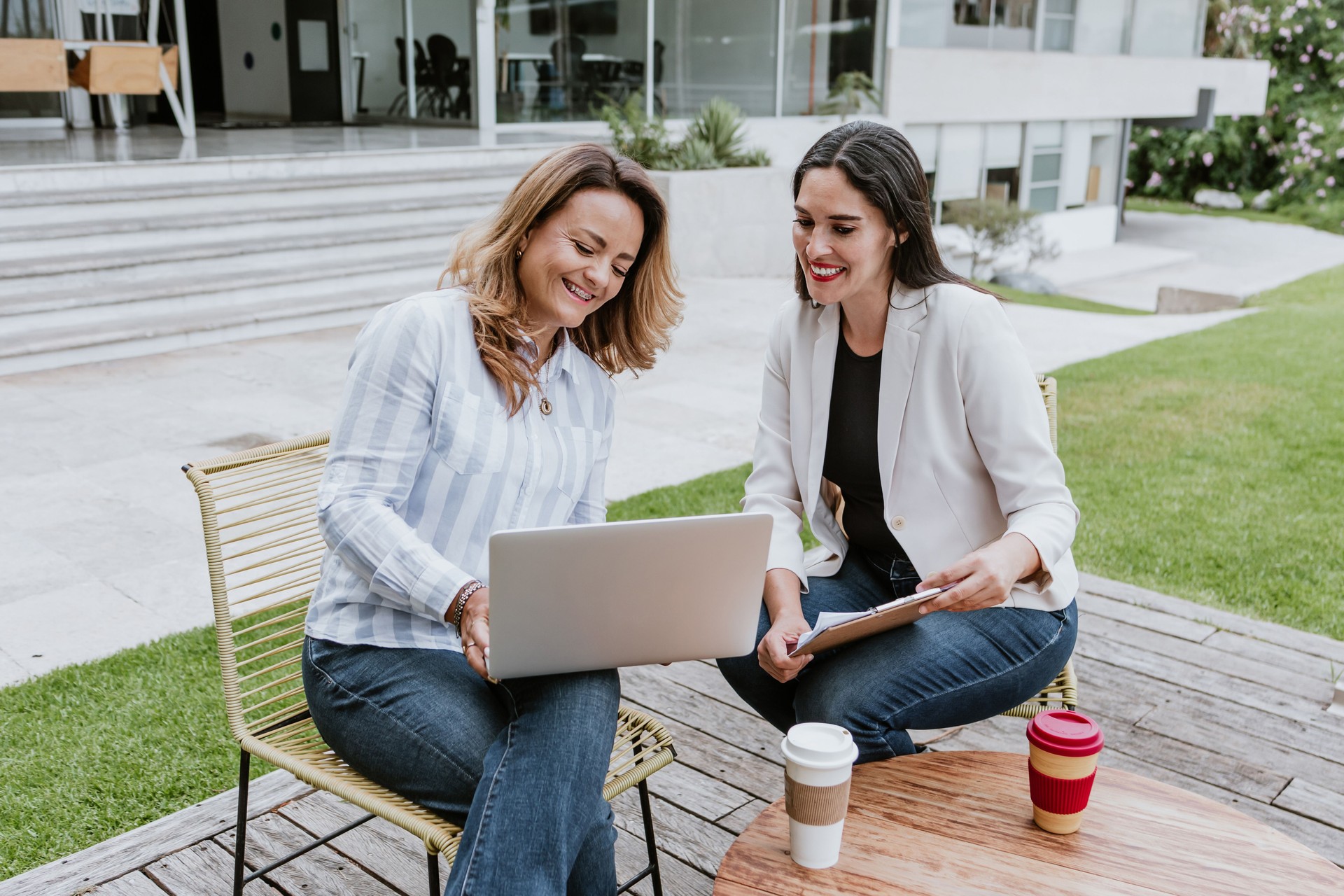 Dos mujeres de negocios latinas de mediana edad, hablando y asesorándose mutuamente en la oficina en México Latinoamérica