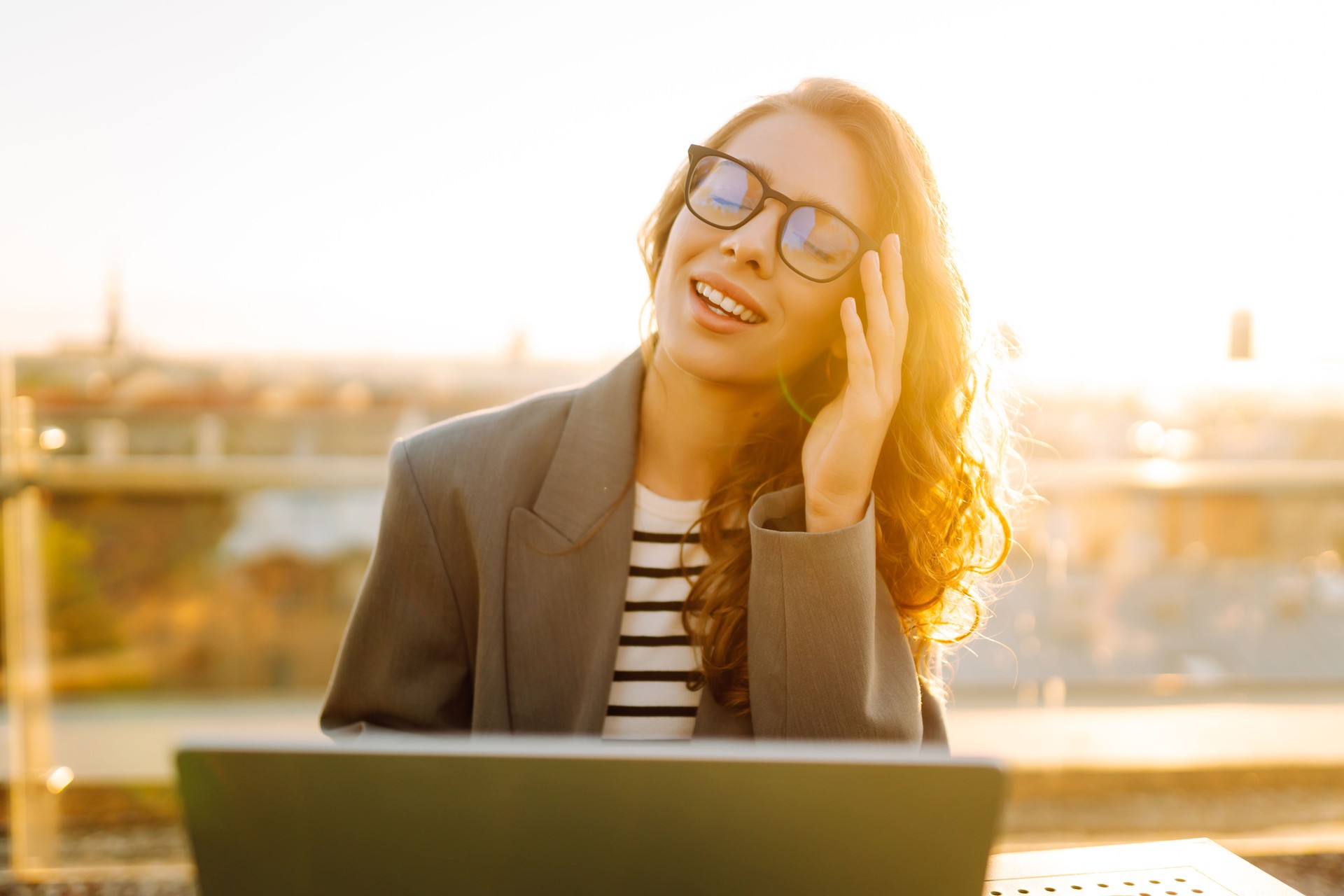 Retrato de una joven mujer de negocios que trabaja con una computadora portátil al aire libre.