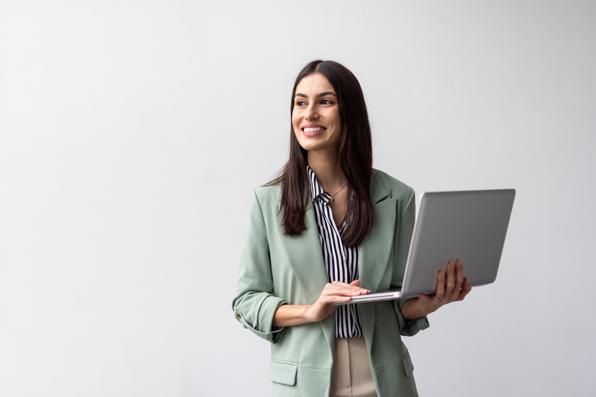 Empresaria latina moderna interactuando con una computadora portátil que sostiene